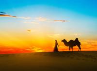 傍晚牵着骆驼的民族少女图片