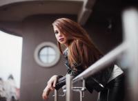 趴在栏杆上扭头的长发美女图片