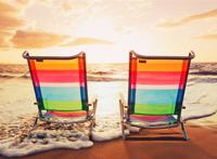 两个彩虹躺椅放在海滩上图片