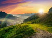 绿色山坡上映出的绚丽的彩虹