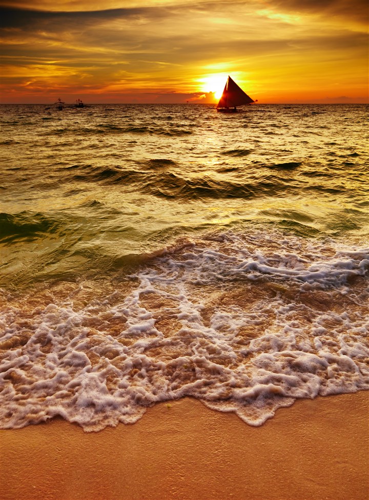傍晚金色沙滩海浪拍打沙滩图片